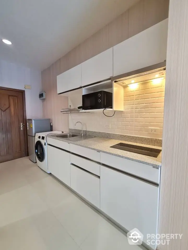 Modern kitchen with sleek cabinetry and built-in appliances in a stylish apartment.