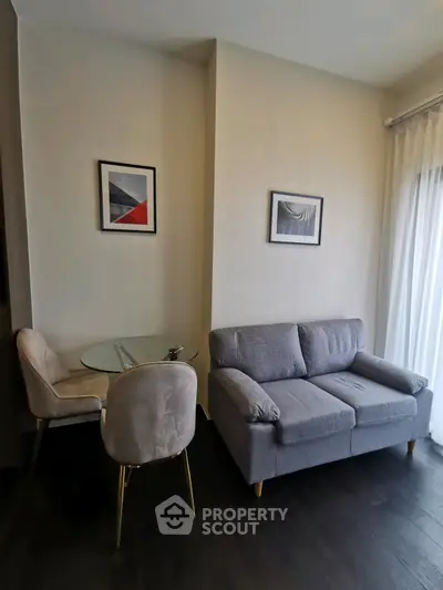 Modern living room with cozy gray sofa and elegant glass dining table