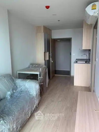 Modern studio apartment with compact kitchen and cozy living area
