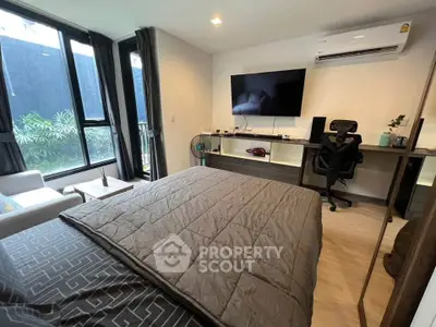 Modern bedroom with large window, stylish decor, and workspace, perfect for comfort and productivity.