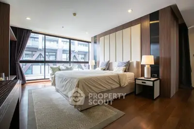 Luxurious modern bedroom with large windows and elegant decor in urban apartment.