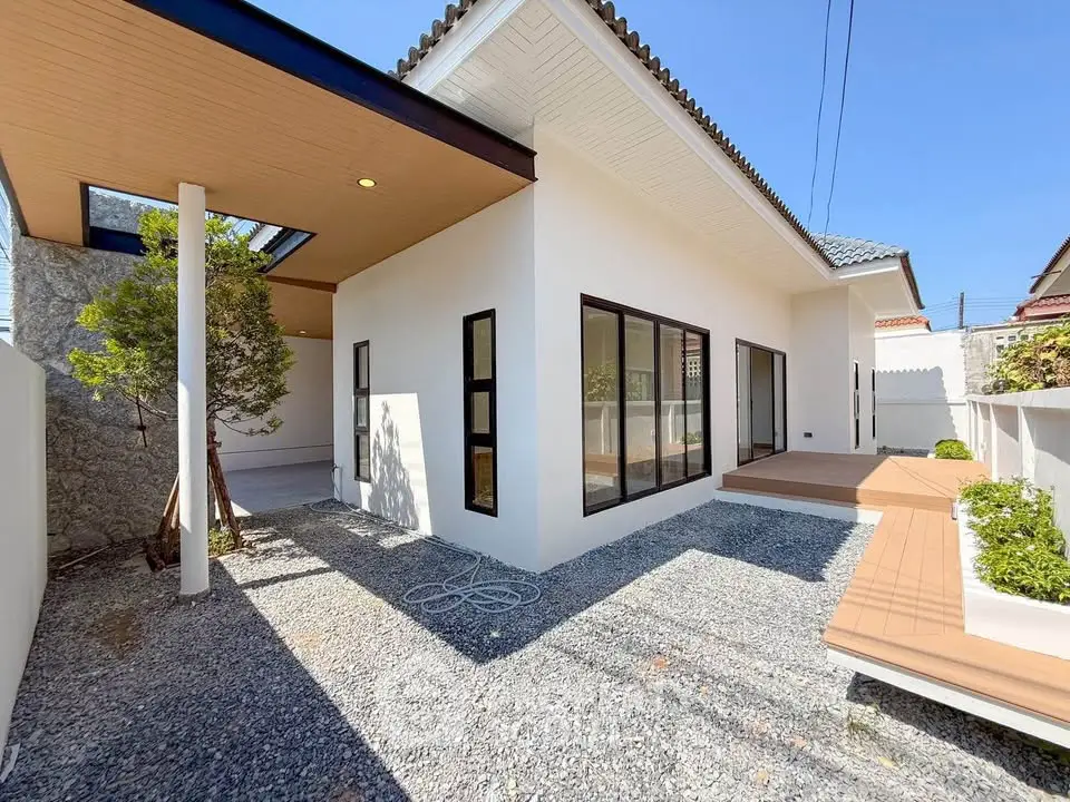 Modern minimalist house exterior with large windows and gravel landscaping