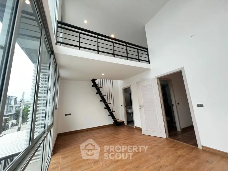 Spacious modern loft with high ceilings and mezzanine in a bright, open living area.