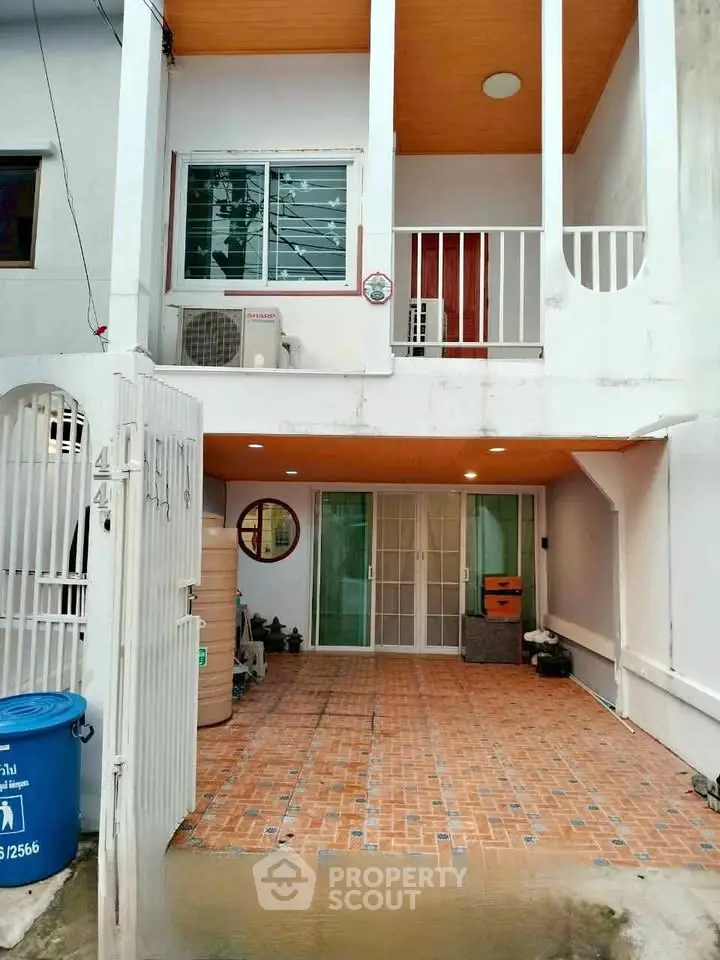Charming two-story townhouse with gated entrance and spacious tiled patio.