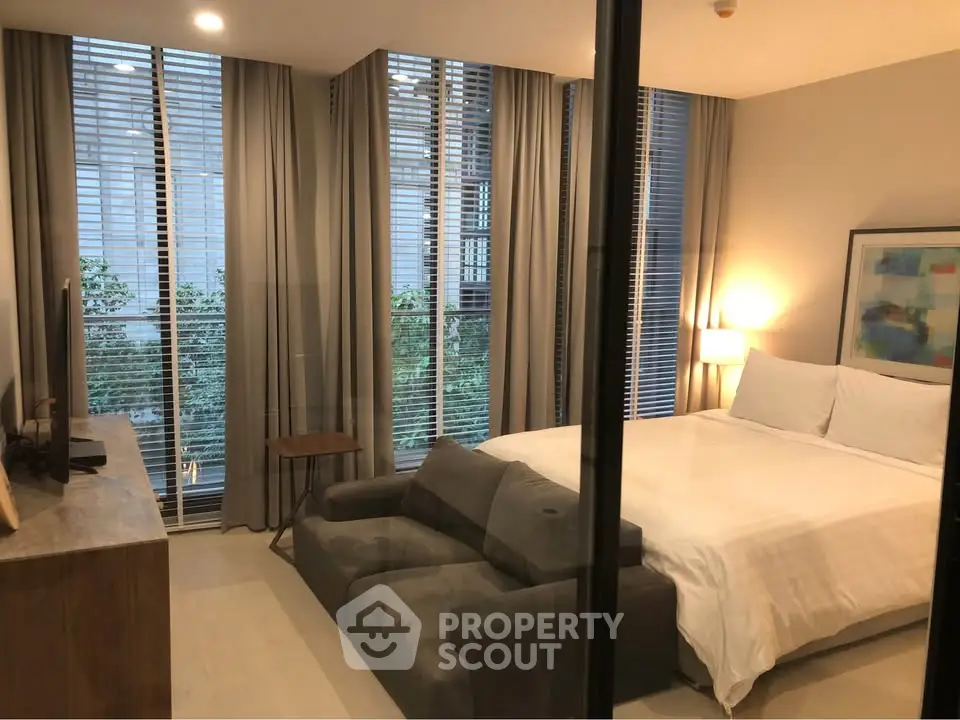Modern bedroom with large windows and stylish decor in a luxury apartment.