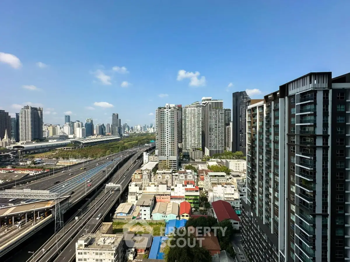 Stunning cityscape view from high-rise apartment with modern buildings and clear blue sky.