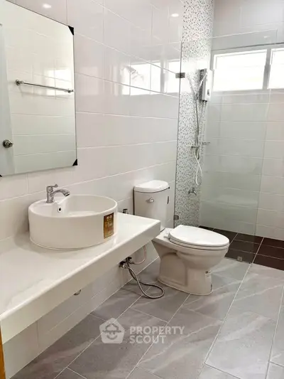 Modern bathroom with sleek fixtures and spacious shower area in a contemporary home.