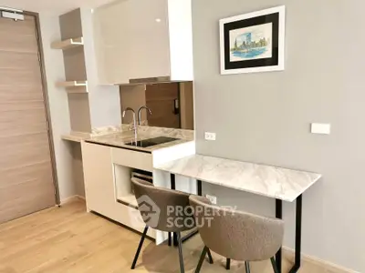 Modern kitchen with sleek design, featuring marble countertops and stylish seating in a contemporary apartment.