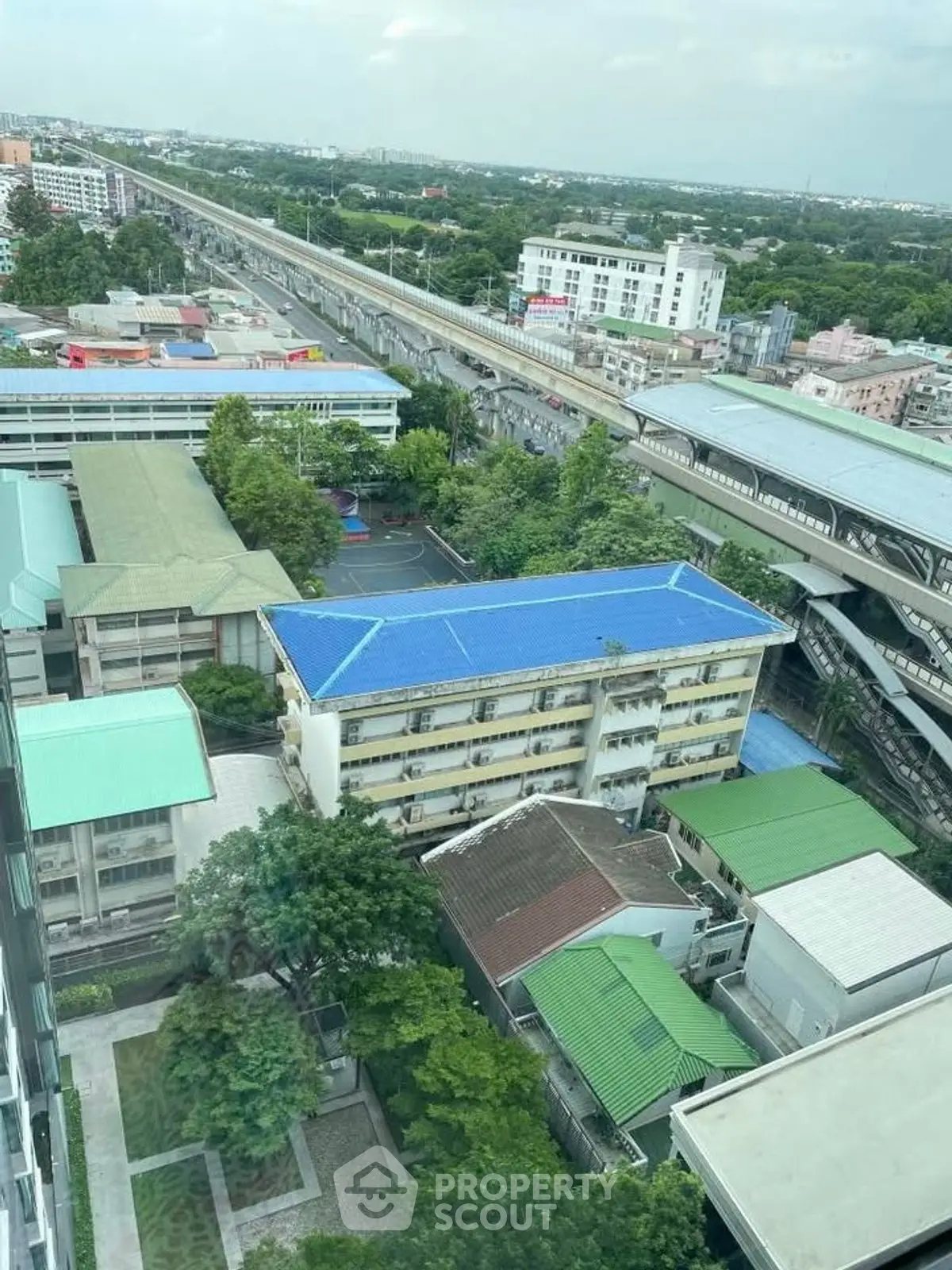 Stunning aerial view of urban landscape with residential buildings and lush greenery, showcasing city living.