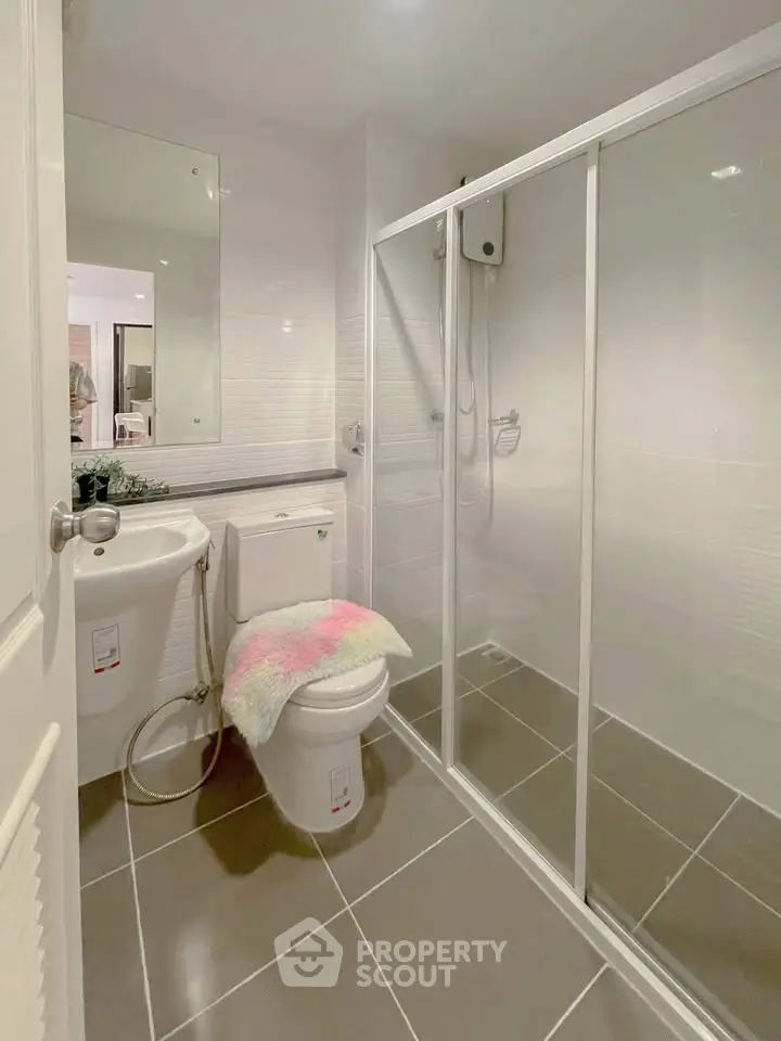 Modern bathroom with glass shower and sleek white fixtures