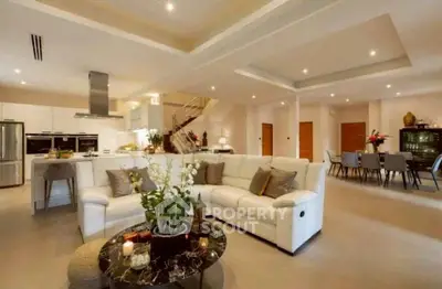 Spacious open-plan living room with modern kitchen and elegant dining area, perfect for entertaining.