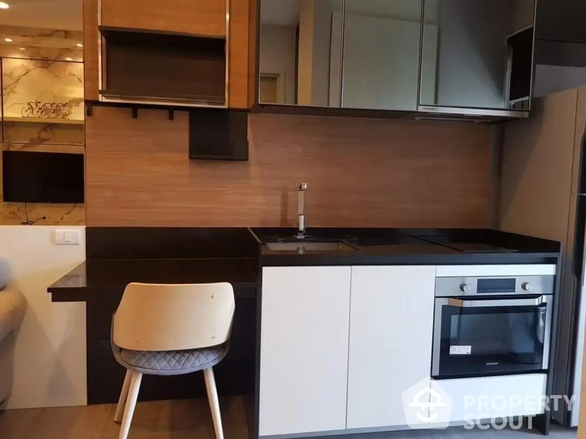 Modern kitchen with sleek cabinetry and built-in oven in stylish apartment