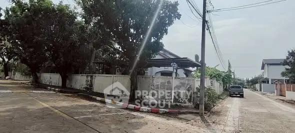 Charming residential street view with lush greenery and spacious surroundings.