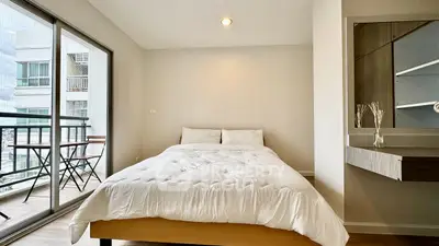 Modern bedroom with balcony access and stylish decor in urban apartment