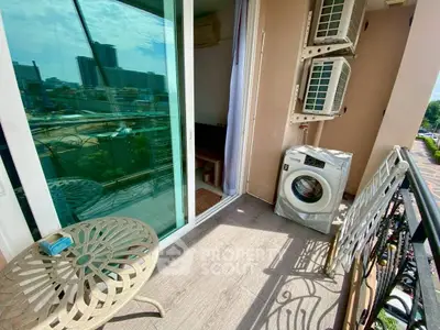 Charming balcony with city view, featuring outdoor seating and washing machine, perfect for urban living.