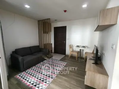 Modern living room with stylish furniture and geometric rug in a cozy apartment.