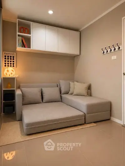 Cozy living room with modern sofa and stylish decor in a compact apartment.