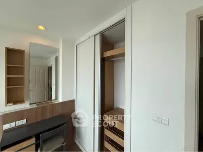 Modern bedroom with built-in closet and sleek desk in a stylish apartment.