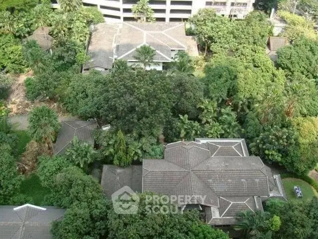 Aerial view of lush residential area with multiple houses surrounded by greenery.