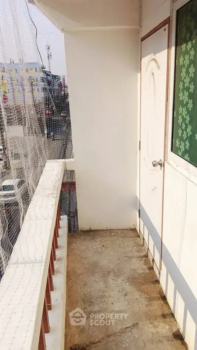 Charming balcony with safety netting and city view, perfect for relaxation and enjoying urban life.