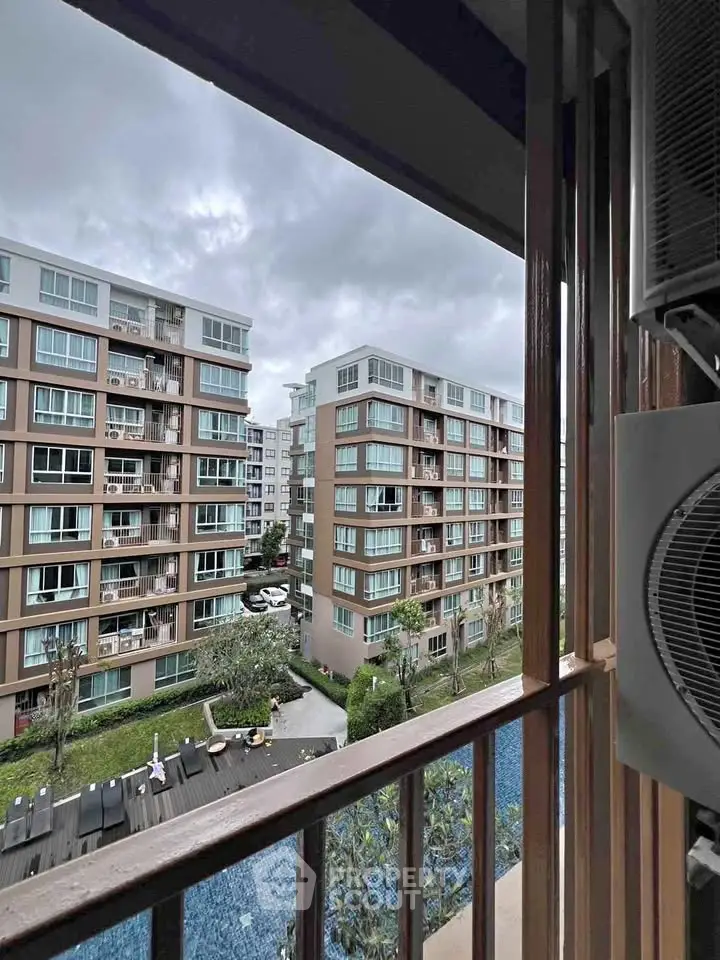 Modern apartment view with pool and garden from balcony, showcasing urban living.