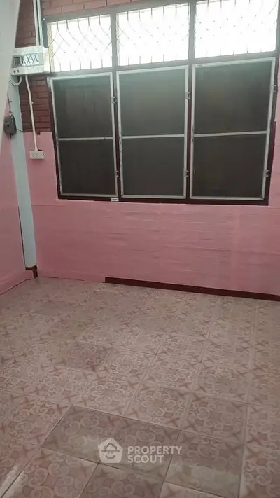 Cozy room with pink walls and patterned tile flooring, perfect for creative design ideas.