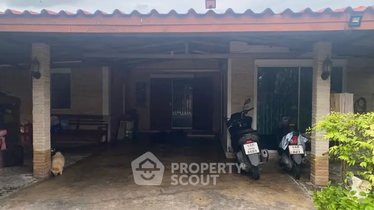 Charming residential entrance with covered parking and motorbikes, perfect for urban living.