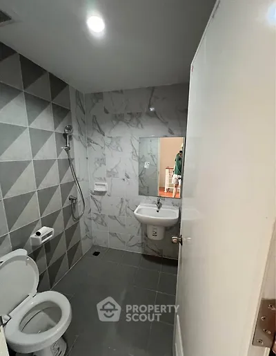 Modern bathroom with geometric tiles and sleek fixtures