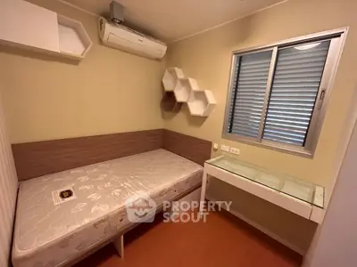 Cozy bedroom with modern design, featuring a single bed, air conditioning, and stylish wall shelves.