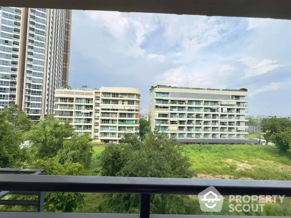 Stunning view from balcony overlooking modern apartment buildings and lush greenery