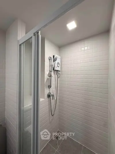 Modern bathroom shower with sleek white tiles and glass door enclosure
