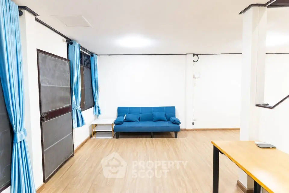 Spacious living room with modern blue sofa and wooden flooring