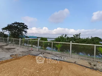 Scenic view of construction site with lush greenery and water body
