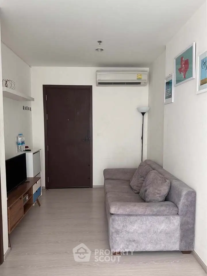 Cozy living room with modern sofa and wall-mounted air conditioner, perfect for relaxation.