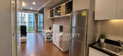 Modern open-plan living room with kitchen and large windows offering city views.