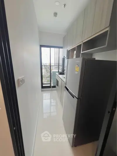 Modern kitchen with sleek appliances and balcony view in a stylish apartment.