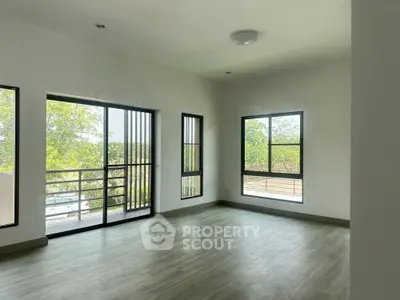 Spacious empty room with large windows and natural light