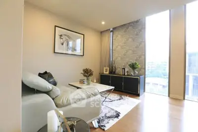 Modern living room with stylish decor and large windows offering natural light and city views.