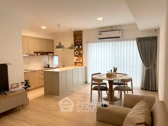 Modern open-plan living room and kitchen with stylish decor and natural light.