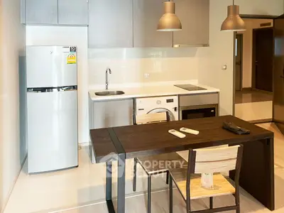 Modern kitchen with sleek appliances and dining area in a stylish apartment.