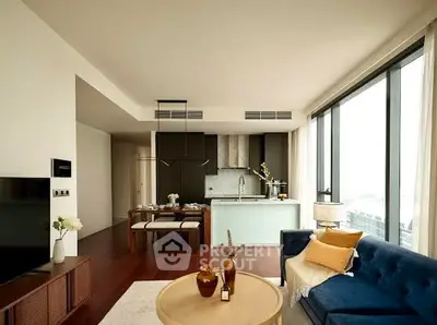 Modern living room with open kitchen and large windows, stylish decor