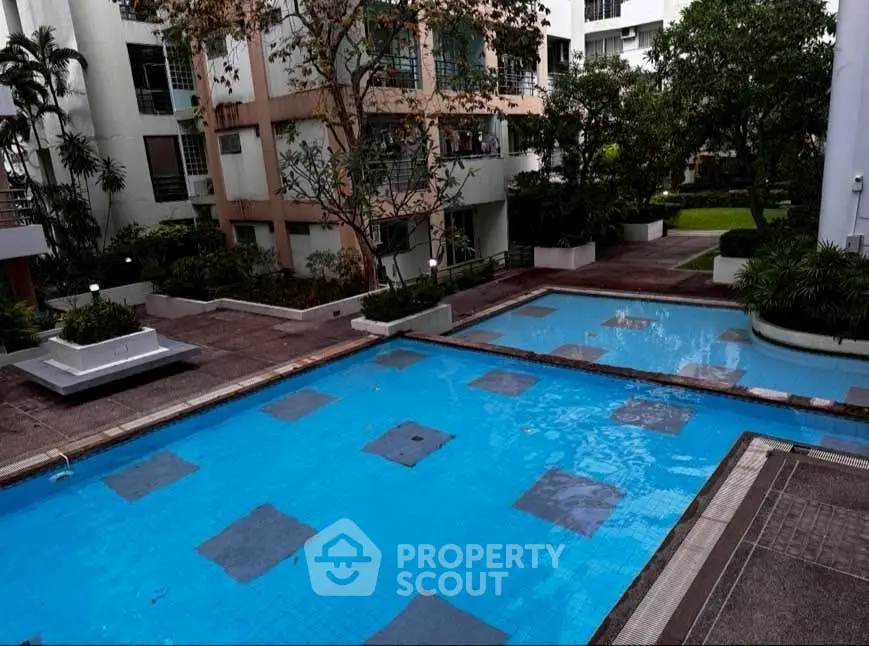 Luxurious residential complex with serene pool and lush greenery