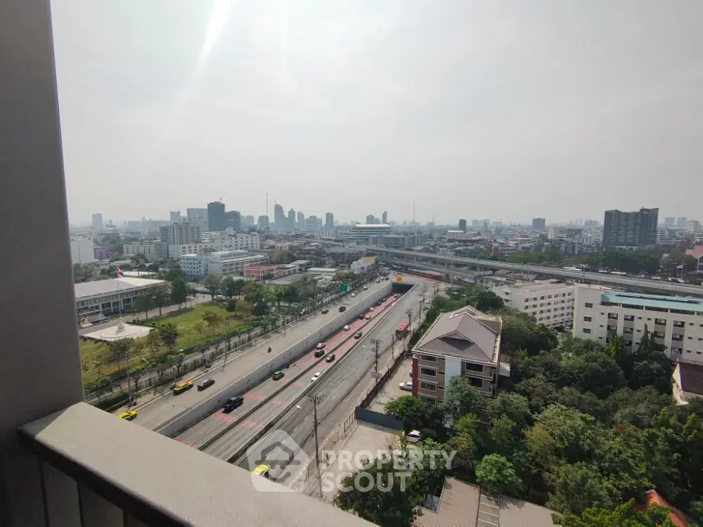 Stunning cityscape view from high-rise balcony overlooking bustling urban landscape.