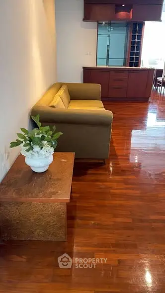 Spacious living room with polished wooden floors and elegant furniture, perfect for modern living.