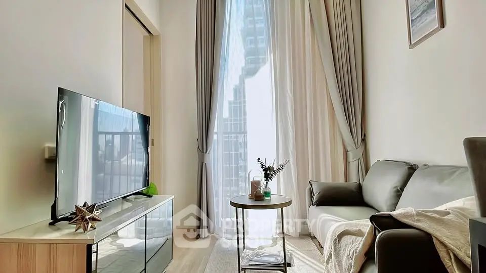 Modern living room with large window, stylish decor, and natural light in urban apartment.