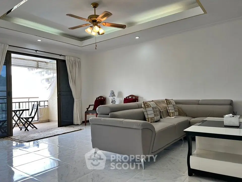 Spacious living room with modern sofa and balcony access in elegant apartment.