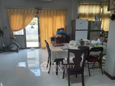 Spacious kitchen with dining area and exercise bike, featuring natural light and modern appliances.