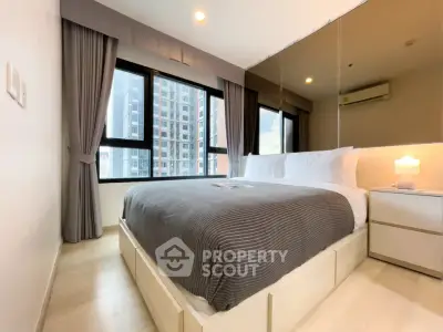 Modern bedroom with large windows and city view in a stylish apartment.