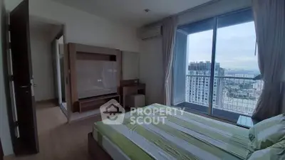 Modern bedroom with large window offering stunning city view and stylish furnishings.