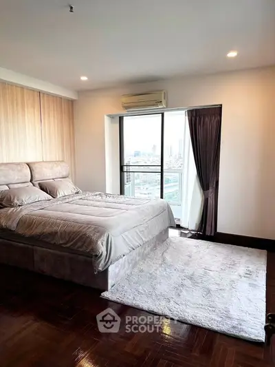 Luxurious bedroom with city view, featuring elegant decor and natural light.